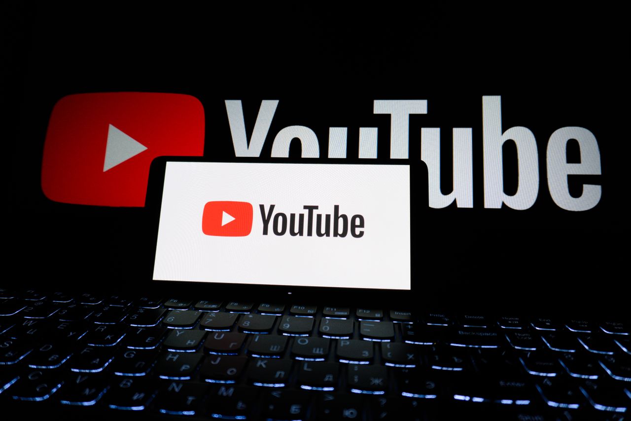 home-hero-bg Close-up of YouTube logo displayed on a laptop screen in a dark environment.